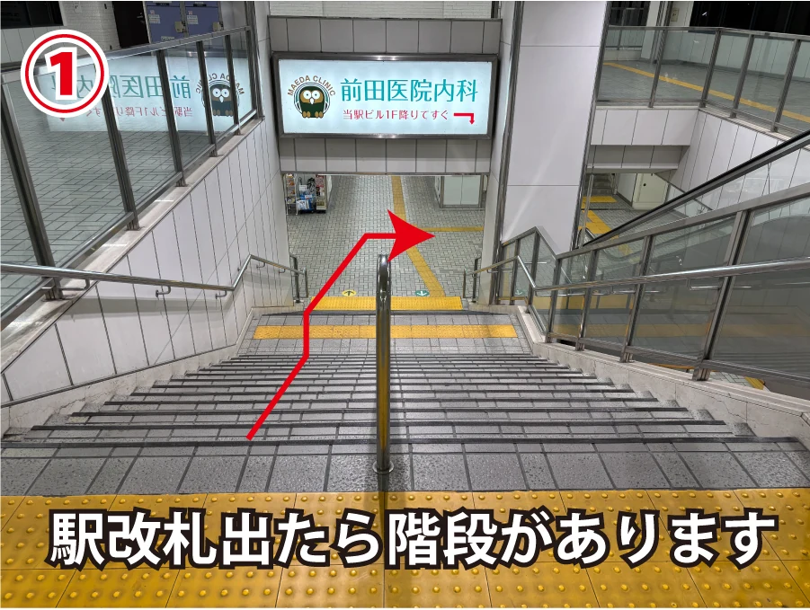 改札を出た先の階段。赤い矢印に沿って下ります